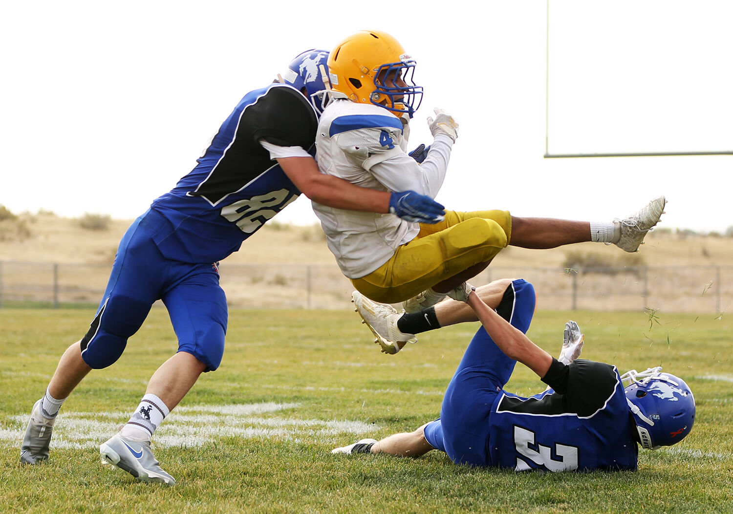 Rhys Stafford, left, and Ethan Devlin take down Sheridan ball carrier Nahir Aguirre